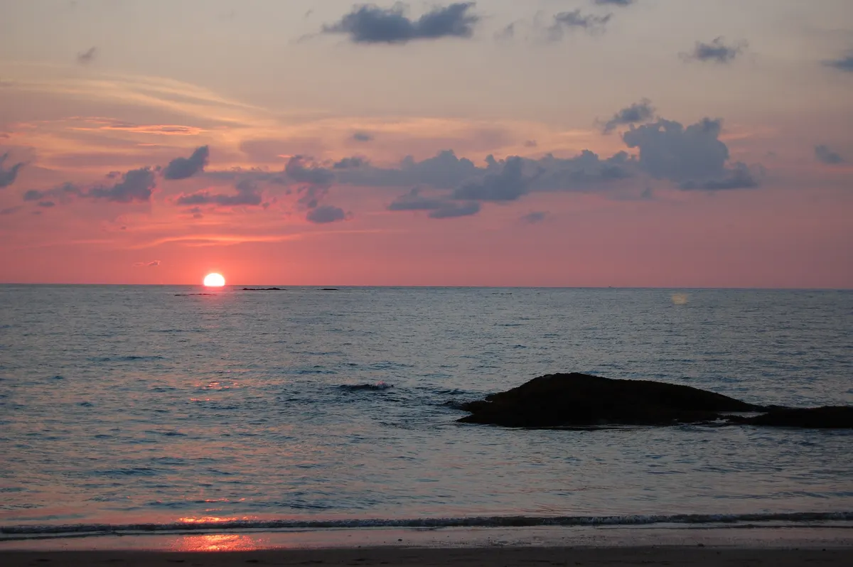 Sunset over the Andaman Sea with a rock off the beach
