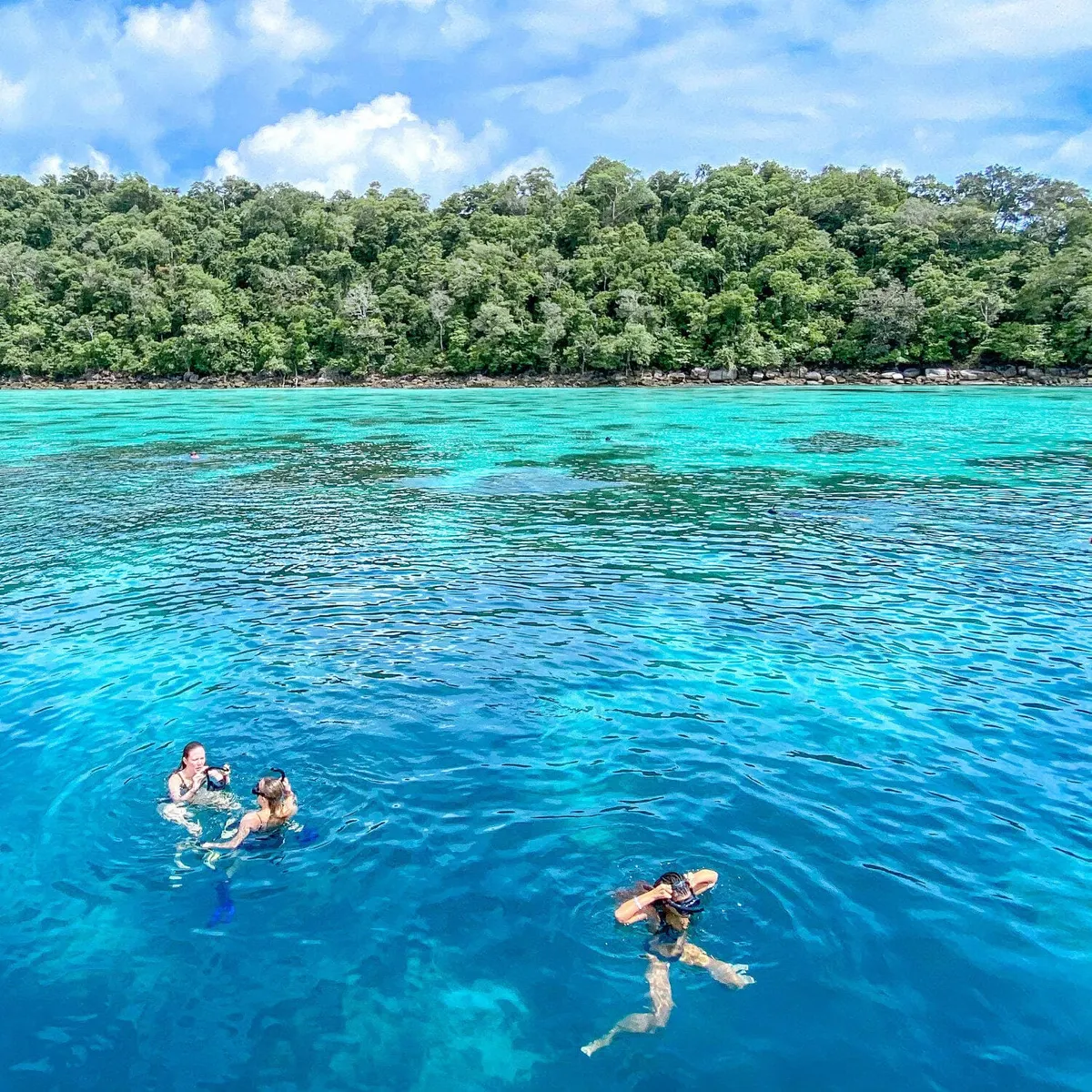 Guests snorkeling in clear blue water at Surin