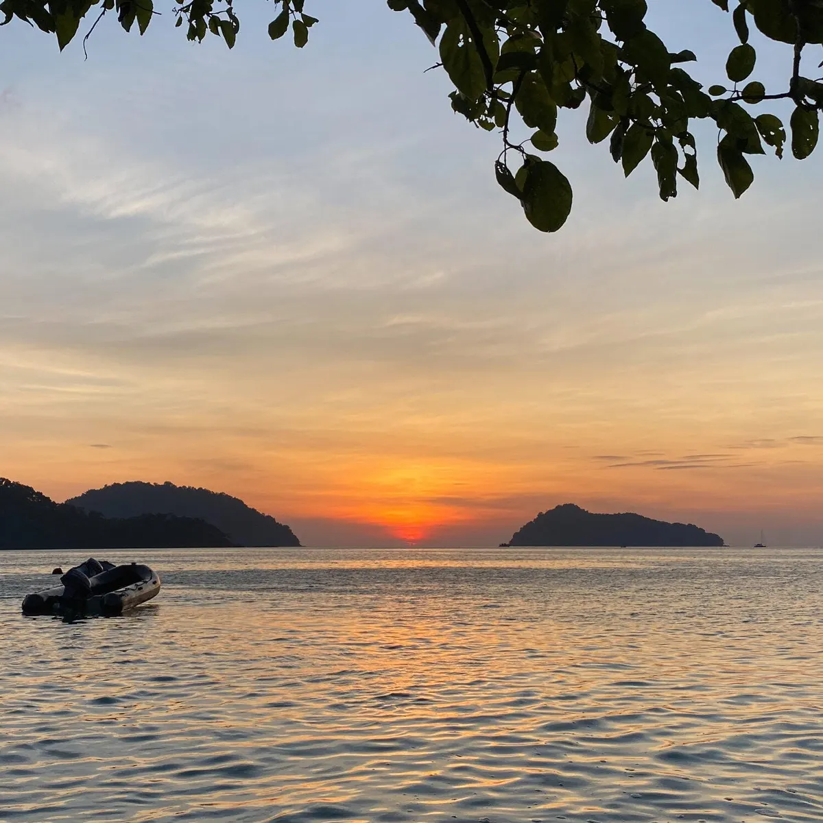 Small boat silhouetted during sunset at Surin