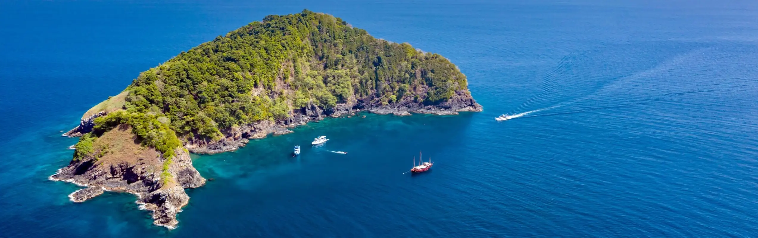Aerial view of Koh Bon with dive boats moored in its sheltered bay